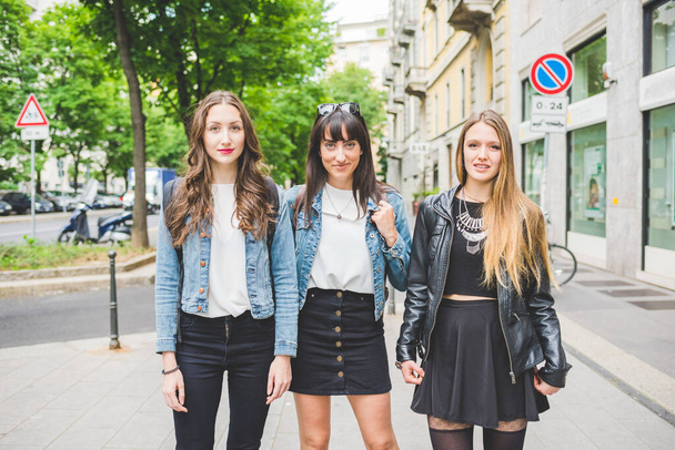 Tres jóvenes hermosas mujeres caucásicas millennials posando al aire libre en la ciudad, sonriendo  - Foto, Imagen