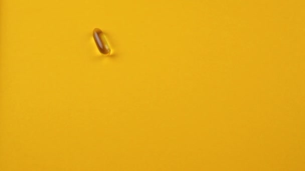 Omega 3 capsule su uno sfondo arancione. Integratori alimentari, vitamine. - Filmati, video