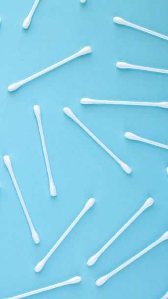 Pattern of white plastic cotton sticks or swabs top view on blue background - Foto, imagen