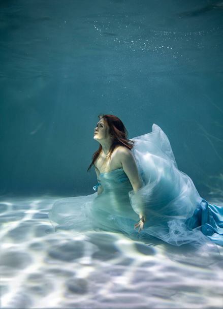gyönyörű lány kék és fehér csempe víz alatt egy kék háttér - Fotó, kép
