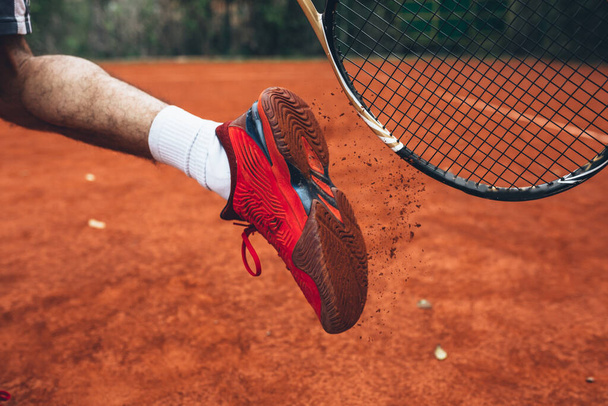 close up tennis player cleaning his sport shoes with racquet - Foto, Imagem