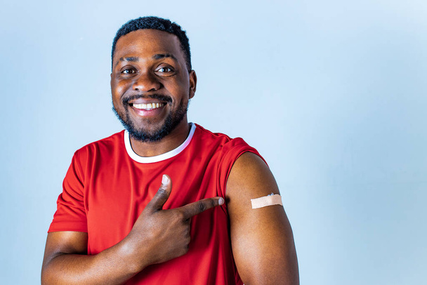 afro american sportsman showing his arm after receiving a vaccine in studio - Photo, image