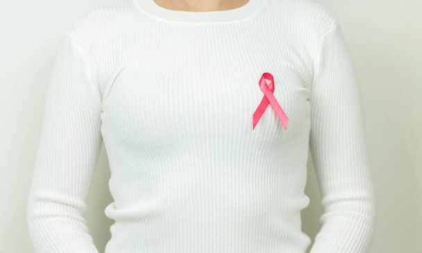 Femme avec ruban rose, symbole de sensibilisation au cancer. Soutenir le concept de cancer du sein et de tumeurs - Photo, image