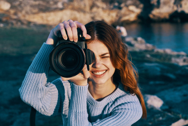 bonita mujer de pelo rojo fotógrafo en la naturaleza paisaje libertad vacaciones - Foto, Imagen