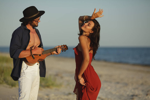 Couple in Love Playing Guitar and Dancing on the Beach - Fotó, kép