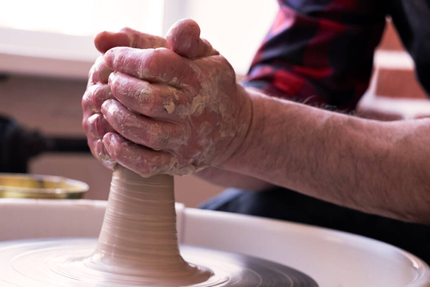 Potterovo kolo a ruce řemeslníka vyrábějícího džbán - Fotografie, Obrázek