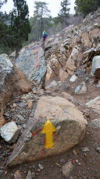 An arrow on the stone indicates the direction of the hiking trail and direction of travel. - Photo, Image