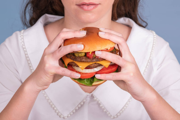 Huge and juicy burger being held by a female - 写真・画像