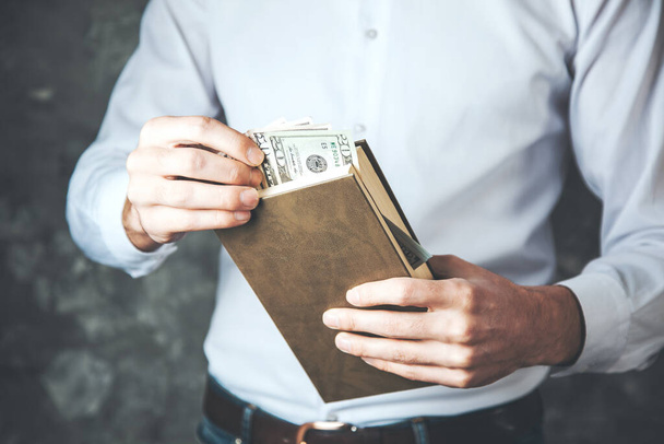 man hand holding money on the book - Фото, изображение