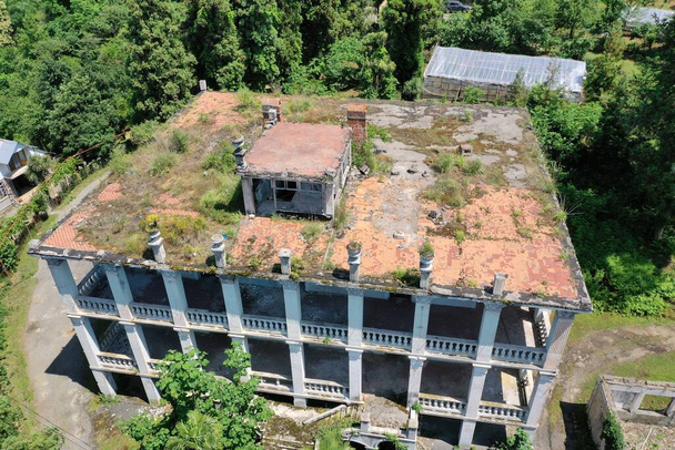 ein zerstörtes Herrenhaus mit rotem Dach aus einer Drohne - Foto, Bild