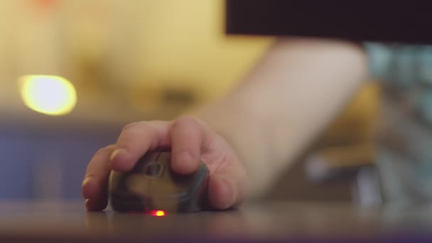 A mão do homem, trabalhando em um computador, clica nos botões de um mouse de computador e gira um pergaminho, luz da noite - Filmagem, Vídeo