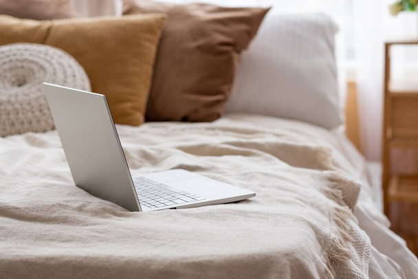 Laptop on a bed at home. Nobody on photo - Foto, afbeelding