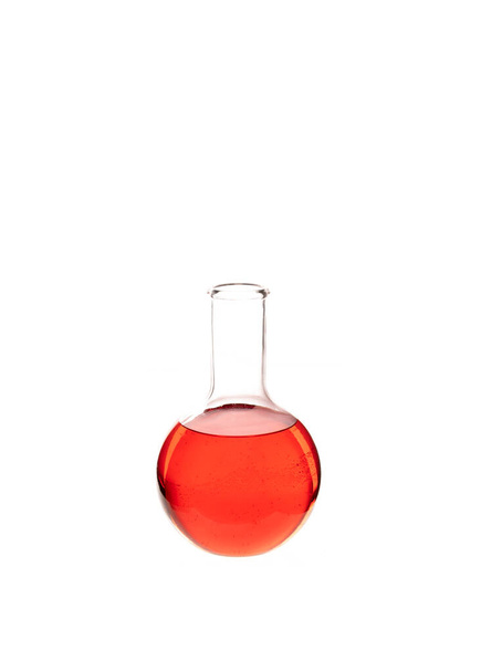 Frasco inferior plano lleno de líquido rojo colorido aislado contra fondo blanco - Foto, imagen