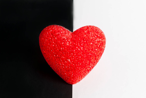 Red heart on black and white background. The heart is in the middle. - Foto, imagen