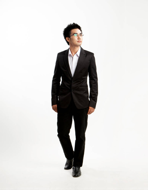 Asian young man wearing glasses, business man black suit on white background - 写真・画像