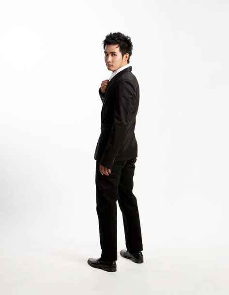 Asiatico giovane uomo girare intorno, stile uomo d'affari vestito nero su sfondo bianco. - Foto, immagini
