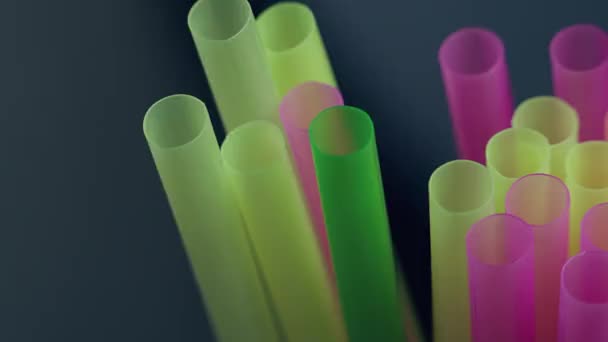 Многоцветные пластиковые коктейльные соломинки, крупный план, движение камеры, темный фон - Кадры, видео