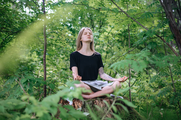 Practice of meditation and interaction with nature. Girl in green forest - Foto, afbeelding