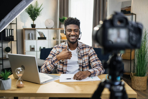 African male blogger in headset recording video on camera - Foto, afbeelding