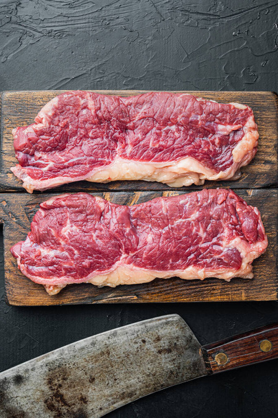 Two fresh raw new york steaks, on black background - Foto, imagen