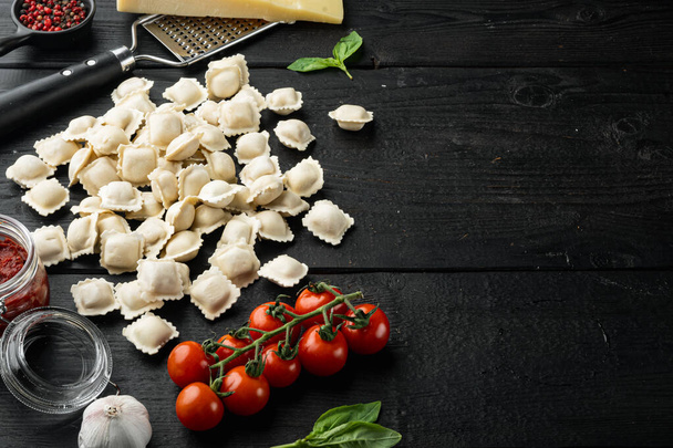 Kotitekoinen tuore italialainen ravioli-pasta, musta puupöydän tausta, jossa on kopiotilaa ja tilaa tekstille - Valokuva, kuva