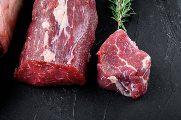 Tenderloin, or Eye Fillet cut raw marbled beef meat set, on black stone background - Foto, Bild