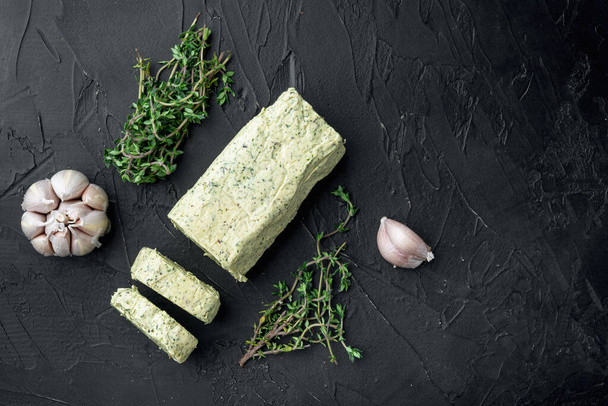 Portion of Herb Butter with Chives, Basil, Oregano, Parsley set, on black stone background, with copy space for text - 写真・画像