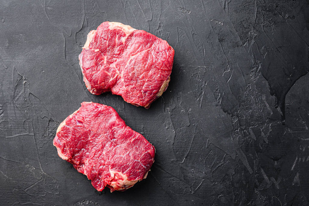 Fresh beef Rump steaks over black background, top view with space for text - Foto, Imagen