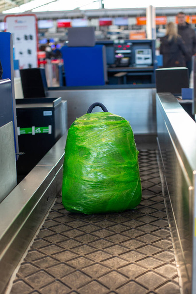 sac à dos en plastique vert pesé au comptoir d'enregistrement avant le départ - Photo, image