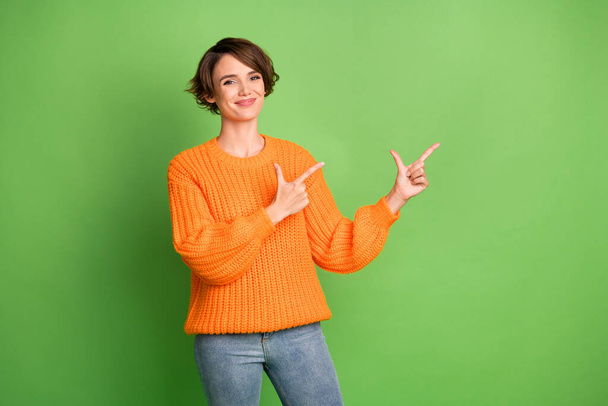Photo of happy attractive young woman promoter point fingers empty space isolated on green color background - Zdjęcie, obraz