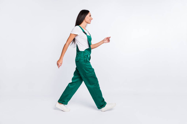 Profile photo of positive pretty lady step wear green overall sneakers isolated white color background - Photo, Image