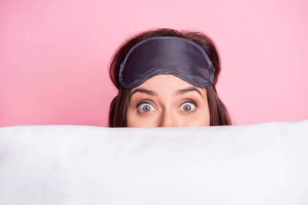 Photo portrait of scared girl hiding behind pillow isolated on pastel pink colored background - Foto, imagen