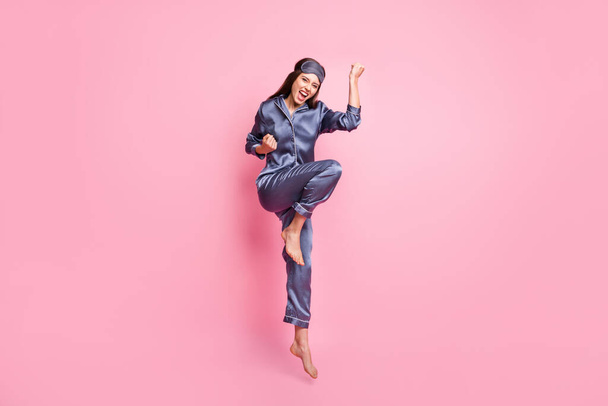 Full length photo portrait of celebrating woman jumping up isolated on pastel pink colored background - Photo, Image