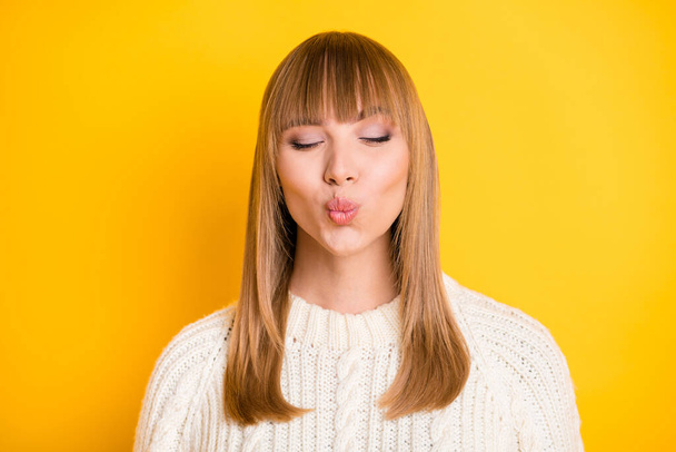 Portrait of adorable positive lady closed eyes kiss lips wearing pullover isolated on bright yellow color background - Foto, afbeelding