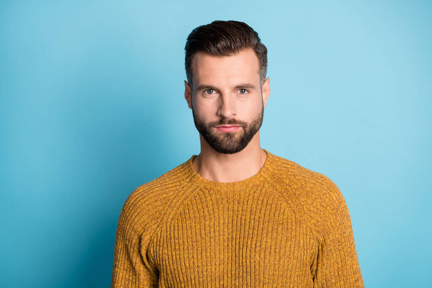Photo of young handsome attractive serious man look camera wear yellow orange sweater isolated on blue color background - Фото, изображение