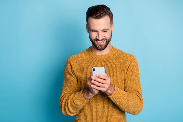 Photo of young happy positive smiling cheerful handsome man using smartphone isolated on blue color background - Valokuva, kuva