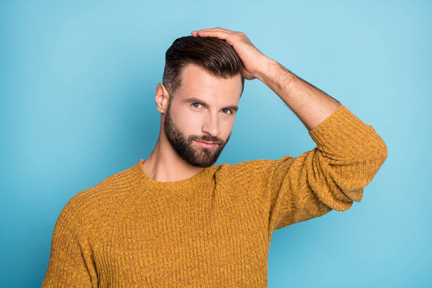 Photo of young charismatic happy attractive handsome man fixing hairstyle wear knitted jumper isolated on blue color background - Valokuva, kuva