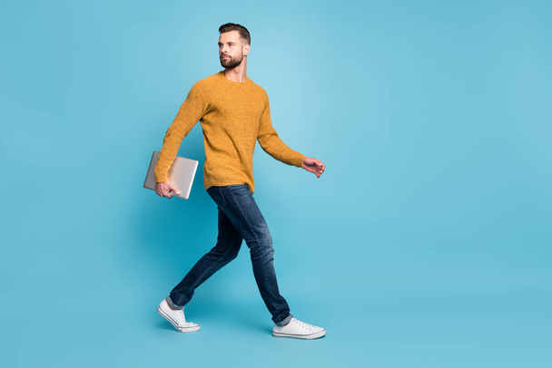 Full length body size view of attractive guy employer going office carrying laptop isolated over bright blue color background - Foto, imagen