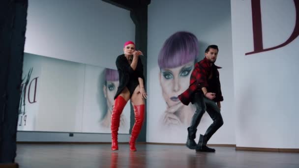 Bailarines de hip hop haciendo ejercicio en el estudio. Hombre y mujer bailando en un club moderno.  - Imágenes, Vídeo