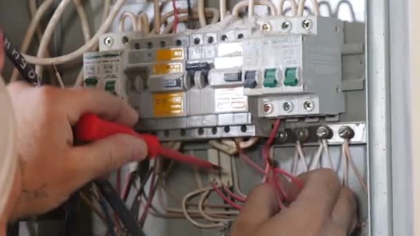Electrician busy with electrical wires in junction box inside wall of residential building apartment. Twisted high voltage cables insulation, professional remodeling of open wires at new apartment. 4 - Footage, Video