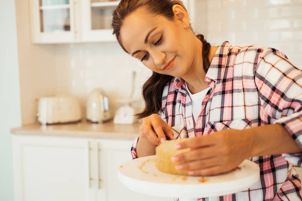 Jeune femme coupe des gâteaux avec un couteau - Photo, image