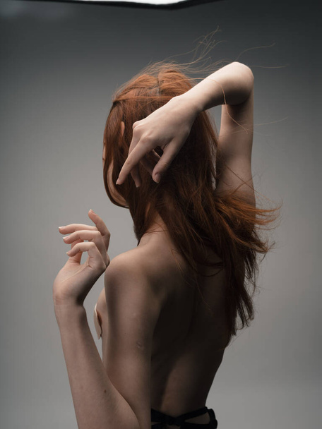 手で自分自身に触れるヌード赤髪の女性  - 写真・画像