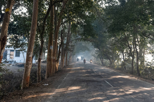 BAREILLY, UTTAR PRADESH, INDIA - DECEMBER 2020 : Indian Road Highways, Beautiful landscape of Indian roads during fog and sunrise in winter morning. Vehicles running on highways. - Photo, Image
