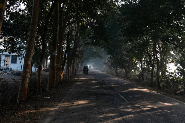 UTTAR PRADESH, Hindistan - 2020 ARALIK: Hint Karayolları, sisli ve kış sabahı gün doğumunda Hindistan yollarının güzel manzarası. Otobanlarda çalışan araçlar. - Fotoğraf, Görsel