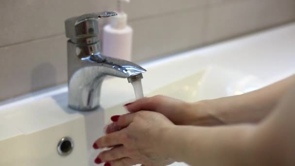 Vista de perto de uma mulher lavando as mãos no banheiro. Uma mulher lava as mãos na bacia de lavagem. - Filmagem, Vídeo