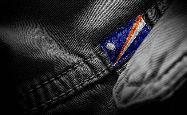 Tag auf dunkler Kleidung in Form der Flagge der Marshallinseln - Foto, Bild