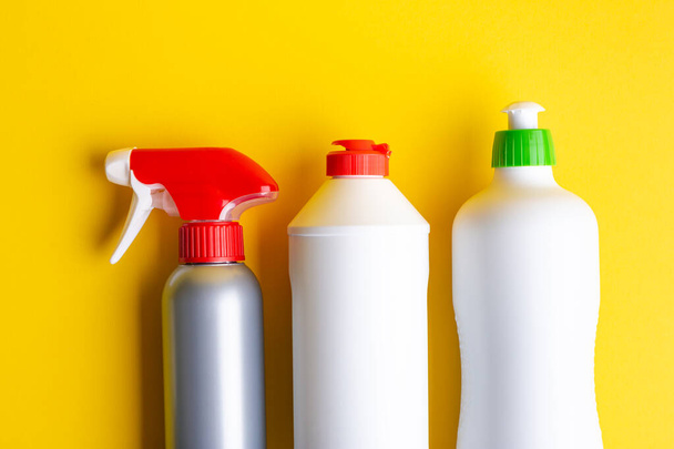 sárga alapon elhelyezett, mosó- és tisztítószerekkel ellátott palackok. azt jelenti, hogy fenntartsák a tisztaság a házban. A szöveg helye - Fotó, kép