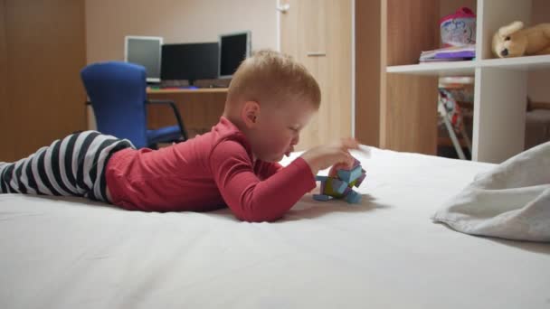 Boy On The Bed With Toy - Materiał filmowy, wideo