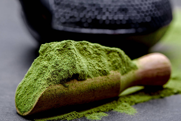 Powdered green tea and set for matcha on black background - Foto, afbeelding