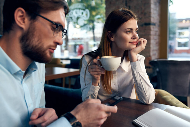 business men and woman sitting in a cafe a cup of coffee leisure communication - Foto, imagen